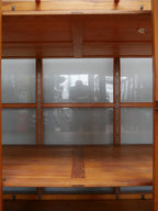 Innenansicht der vollständig verglasten Rückwand. Die Aufnahme verdeutlicht die außergewöhnliche Konstruktion, die eine freie Aufstellung der Vitrine im Raum ermöglicht.