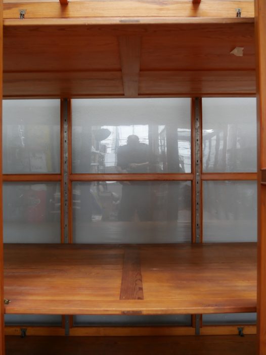 Innenansicht der vollständig verglasten Rückwand. Die Aufnahme verdeutlicht die außergewöhnliche Konstruktion, die eine freie Aufstellung der Vitrine im Raum ermöglicht.