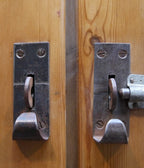 Nahaufnahme der originalen Metallverriegelung des historischen Weichholz-Spinds mit authentischen Beschlägen und restaurierter Oberfläche.