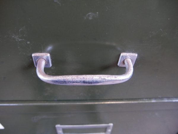 Nahaufnahme des originalen vernickelten Metallgriffs einer Schublade am Otto Brückner Werkzeugschrank.