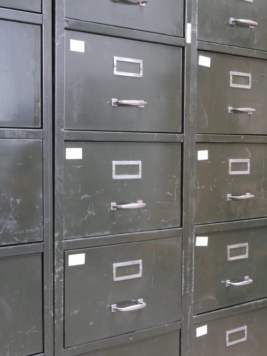 Detailansicht der originalen Metallschubladen mit vernickelten Griffen und Etikettenhaltern.