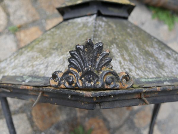 Detailaufnahme der dekorativen Firstzier auf dem Dach einer originalen Gründerzeit-Laterne aus Gusseisen um 1880. Die kunstvoll ausgearbeitete Bekrönung mit authentischer Patina unterstreicht die hochwertige handwerkliche Ausführung und den original erhaltenen Charakter des historischen Laternenpaares.