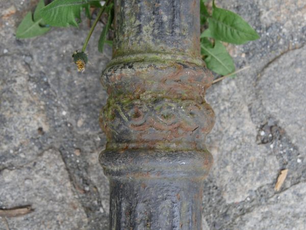 Detailaufnahme der beiden gusseisernen Laternenmasten mit den typischen vertikalen Profilierungen der Gründerzeit.