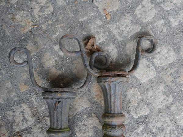 Detailaufnahme der dekorativen oberen Gusseisen-Verzierungen mit geschwungenen Ornamenten und historischen Befestigungselementen.