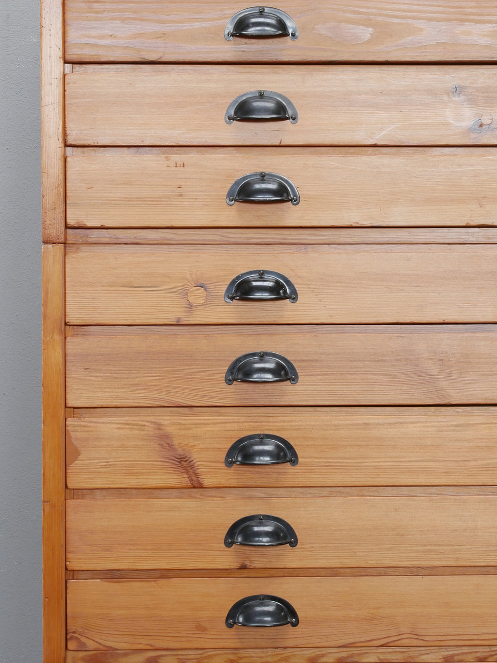 Nahaufnahme der originalen Metallgriffe und restaurierten Holzfronten des REISS Planschrank.