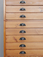 Nahaufnahme der originalen Metallgriffe und restaurierten Holzfronten des REISS Planschrank.