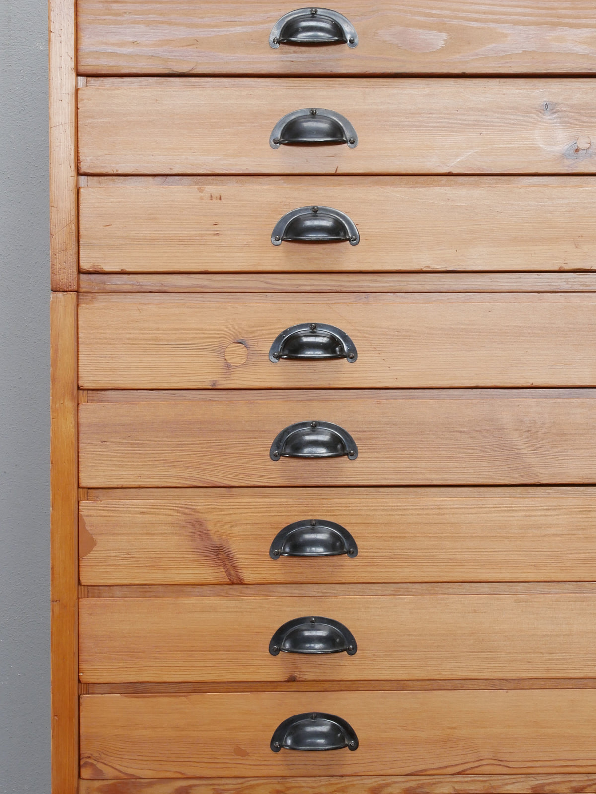 Nahaufnahme der originalen Metallgriffe und restaurierten Holzfronten des REISS Planschrank.