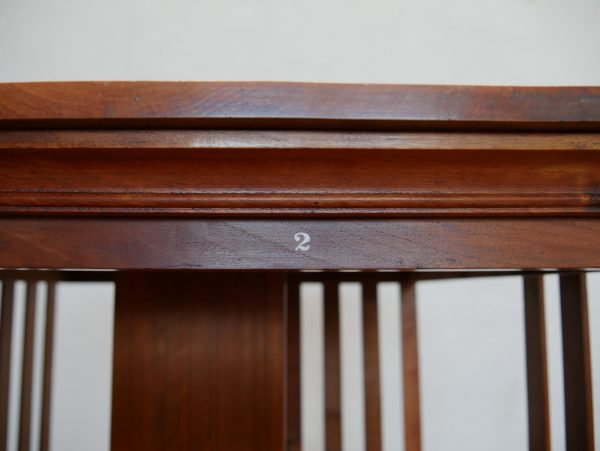Detailaufnahme der original erhaltenen Fachnummer „2“ auf der oberen Zarge des drehbaren Revolving Bookcase von Hollandia H. Pander & Zonen. Die historische Nummerierung der Bücherfächer ist teilweise erhalten und dokumentiert den authentischen Originalzustand dieses seltenen Jugendstil-Bücherkarussells aus massivem Nussbaum um 1890–1900.
