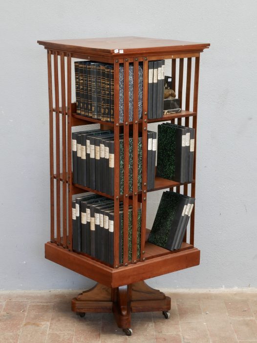 Schräge Seitenansicht des Revolving Bookcase von Hollandia H. Pander & Zonen. Die Aufnahme zeigt die offene Fachaufteilung, die hochwertige Verarbeitung aus massivem Nussbaum sowie die elegante Jugendstil-Konstruktion des drehbaren Bücherregals.

