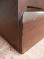 Detailaufnahme der unteren Möbelecke mit Sockel und sauber gearbeiteten Holzverbindungen. Die massive Bauweise der Deutschen Werkstätten Hellerau wird sichtbar.
