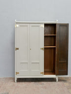 Der dreitürige Jugendstil-Kleider- und Wäscheschrank mit geöffneter rechter Schrankseite. Sichtbar werden die originalen Einlegeböden des Wäscheschranks und der hochwertige Innenausbau.
