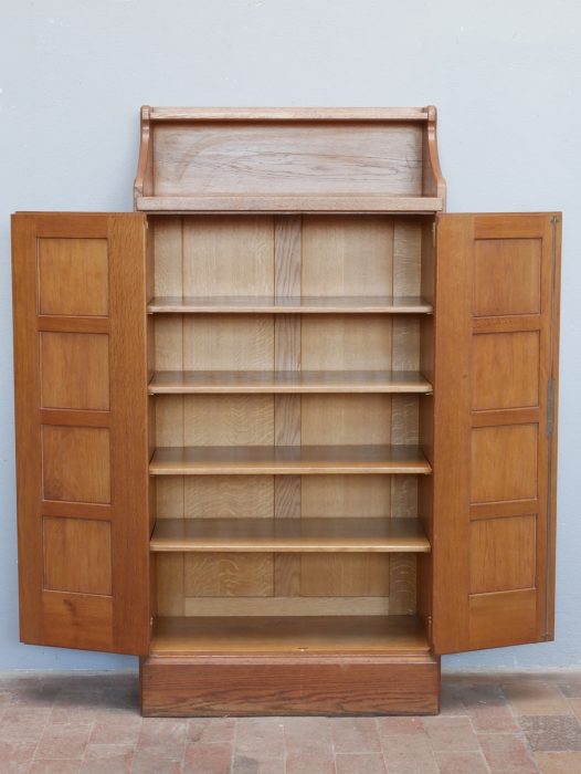 Pfeilerschrank mit vollständig geöffneten Türen. Der großzügige Innenraum mit den originalen Einlegeböden zeigt die hochwertige Innenausstattung und die praktische Funktion als Bücher- oder Aktenschrank.