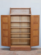 Pfeilerschrank mit vollständig geöffneten Türen. Der großzügige Innenraum mit den originalen Einlegeböden zeigt die hochwertige Innenausstattung und die praktische Funktion als Bücher- oder Aktenschrank.