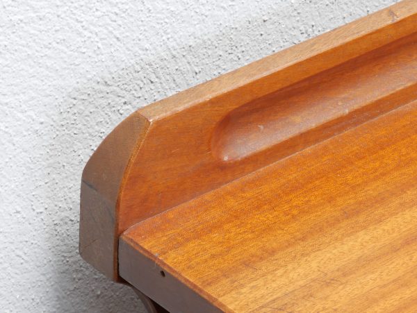 Detailaufnahme der elegant gerundeten Ecke der massiven Schreibtischplatte. Die harmonische Linienführung und die fein bearbeitete Mahagoni-Oberfläche spiegeln die sachliche Formensprache Richard Riemerschmids und die hohe handwerkliche Qualität wider.