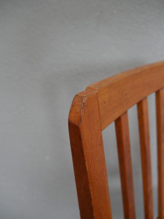 Detailaufnahme des oberen Abschlusses der Rückenlehne eines originalen Richard-Riemerschmid-Stuhls. Die leicht geschwungene obere Traverse und die fein erhaltene Holzoberfläche zeigen den authentischen Originalzustand des Jugendstil-Möbels.