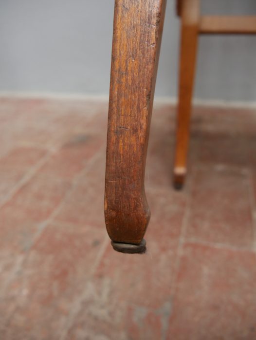 Detailaufnahme eines Vorderbeins mit originaler Holzoberfläche. Die Aufnahme zeigt die elegante Verjüngung des Stuhlbeins sowie die hochwertige Verarbeitung des historischen Jugendstil-Stuhls.
