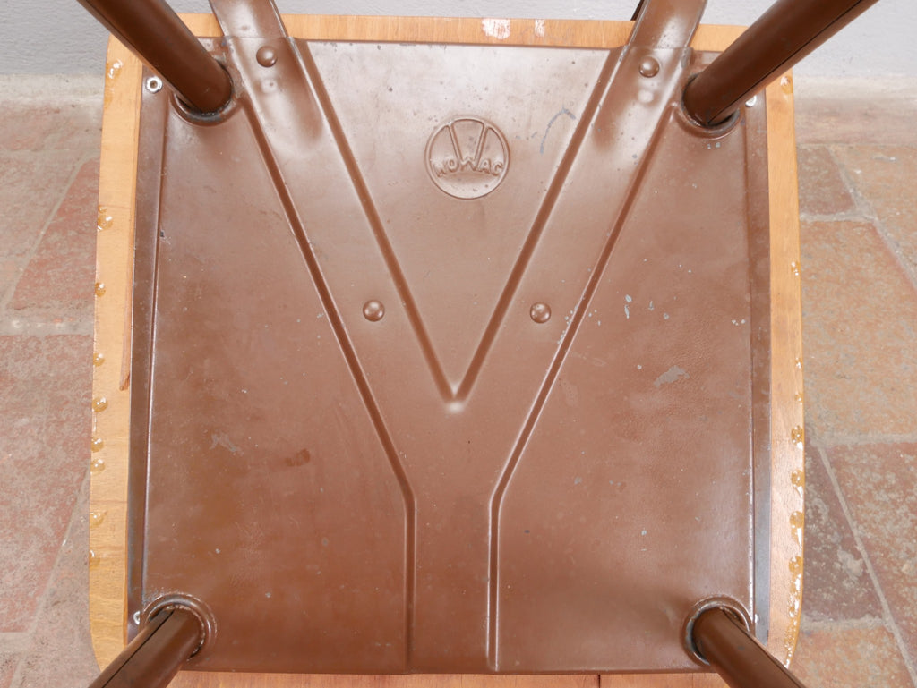Detailansicht der Unterseite  der massiven Holzsitzfläche mit den originalen Befestigungen am Metallgestell und dem Herstellerstempel. Die Verarbeitung und die authentische Patina unterstreichen den unrestaurierten Originalzustand.
