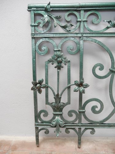 Detail eines seitlichen Geländerelements mit senkrechten Stäben, geschwungenen Ornamenten und dekorativen Schmiedeverbindungen. Die hochwertige Verarbeitung zeigt den repräsentativen Charakter des ehemaligen Schlossgeländers.
