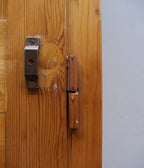 Nahaufnahme eines originalen, mit Holz verkleideten Scharniers des restaurierten Weichholz-Spinds aus der Zeit um 1915.