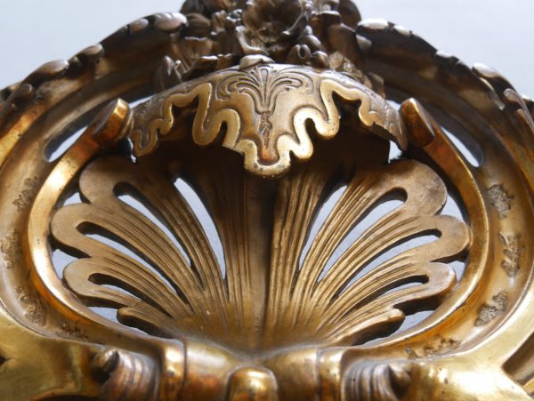 Detailaufnahme eines reich geschnitzten Muschelornaments im oberen Bereich des Spiegelrahmens. Die plastische Ausarbeitung und die originale Vergoldung zeigen die hohe Qualität der historischen Handwerkskunst.