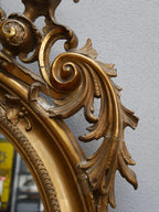 Detailaufnahme des seitlichen Spiegelrahmens mit kunstvoll geschnitzten Blatt- und Rollornamenten. Die originale Vergoldung und die schöne Alters-Patina sind hervorragend erkennbar.