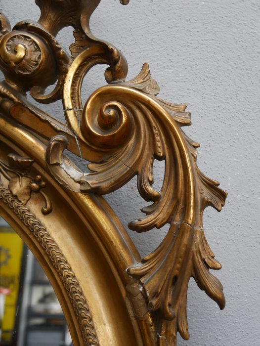 Detailaufnahme des seitlichen Spiegelrahmens mit kunstvoll geschnitzten Blatt- und Rollornamenten. Die originale Vergoldung und die schöne Alters-Patina sind hervorragend erkennbar.