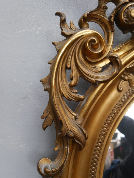 Detailaufnahme des seitlichen Rahmenprofils mit original vergoldeter Profilierung und fein gearbeiteten Zierelementen. Die Aufnahme dokumentiert die hochwertige handwerkliche Verarbeitung des historischen Spiegelrahmens.