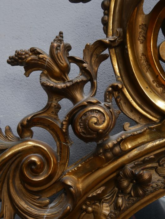 Nahaufnahme eines seitlichen Rahmenabschnitts mit vergoldeten Schnitzereien und dekorativen Profilierungen. Sichtbar sind die originale Oberflächenpatina sowie die feine handwerkliche Ausarbeitung.