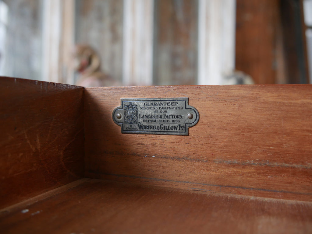 Originale Herstellerplakette von Waring & Gillow England am historischen Bureau Plat.