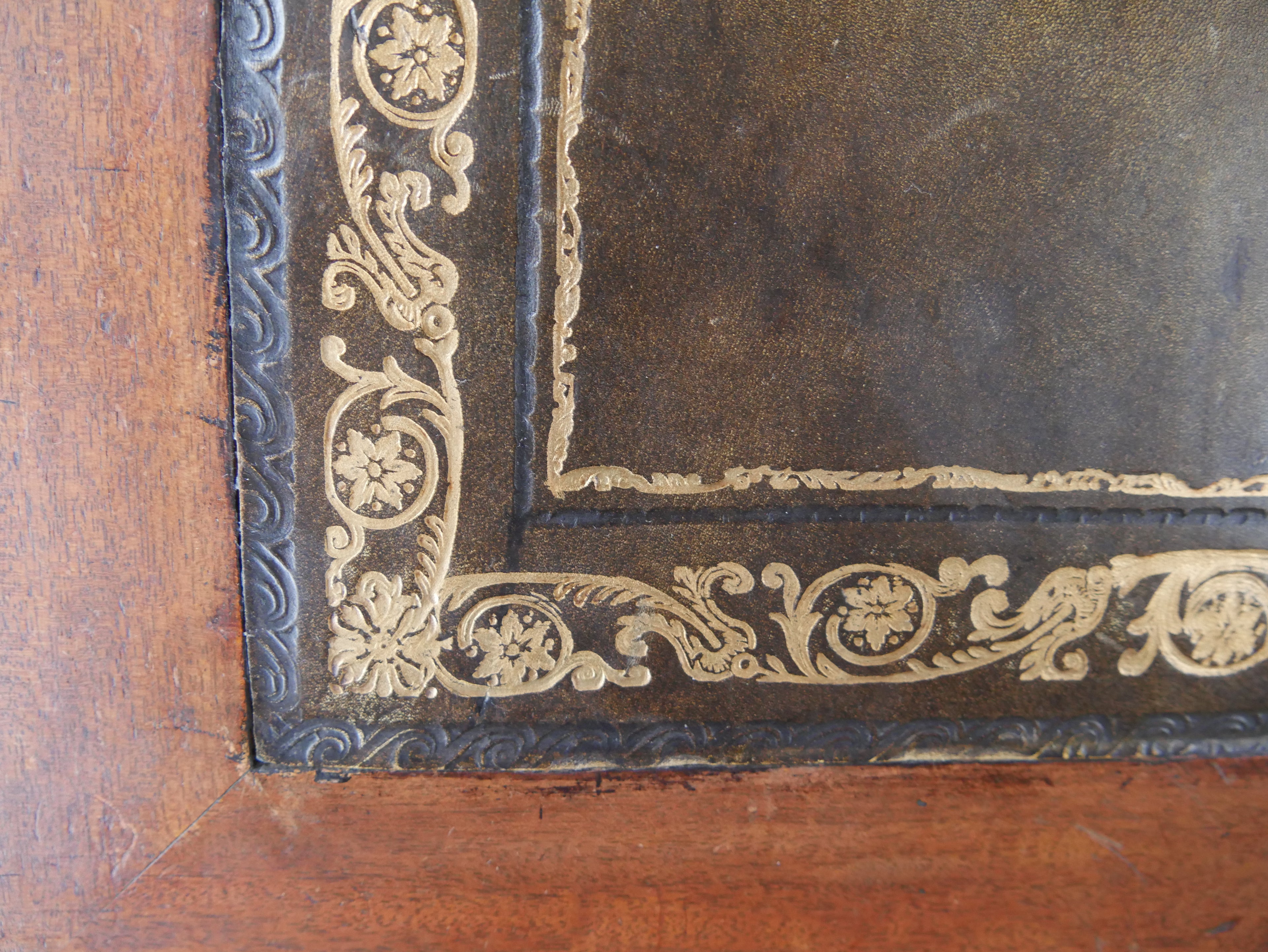 Detail der original geprägten dunkelgrünen Ledereinlage mit goldener Zierbordüre.