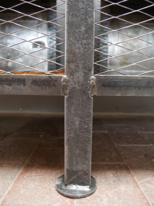 Detailaufnahme des seitlichen Metallgitters und der genieteten Stahlkonstruktion der historischen Werkbank. Die originale Industrieausführung wurde sorgfältig restauriert.