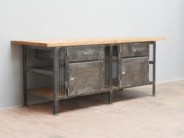 Seitenansicht der historischen Werkbank mit stabilem Stahlgestell, massiver Arbeitsplatte und restauriertem Metallkorpus im originalen Industriedesign.