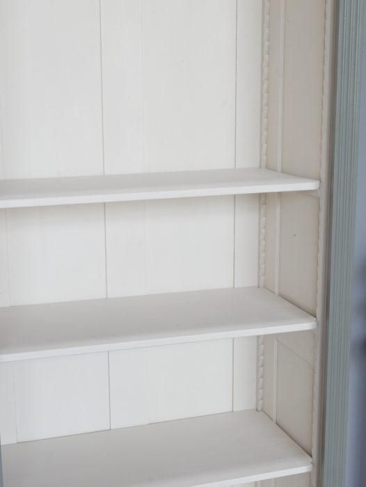 Innenansicht der Bibliothek mit den cremeweißen, höhenverstellbaren Einlegeböden. Die Fachböden lassen sich mittels Zahnleisten individuell verstellen und bieten großzügigen Stauraum für Bücher oder Sammlerstücke.