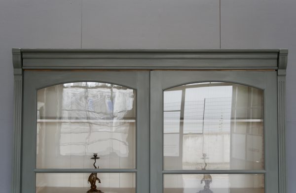Detailaufnahme des oberen Bereichs mit den beiden großen Schiebetüren und dem originalen mundgeblasenen Glas. Die feinen Holzprofile und die hochwertige Verarbeitung des Schranks stehen im Mittelpunkt.
