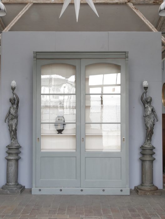 Frontansicht der restaurierten XXL Bibliothek mit geschlossenen Schiebetüren. Die symmetrische Gestaltung, das originale mundgeblasene Glas sowie die elegante grau-blaue Farbgebung kommen besonders gut zur Geltung.