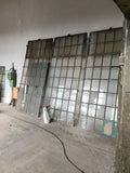 Großes originales XXL-Fabrikfenster aus Schmiedeeisen von etwa 1900 in gutem bis sehr gutem Bergezustand. Die Aufnahme zeigt das historische Industriefenster mit zahlreichen Sprossenfeldern und integriertem Oberlicht, das sich mittels Kette öffnen lässt. Ideal als Restaurierungsobjekt, Loftfenster oder architektonisches Gestaltungselement im Industrie- und Landhausstil.