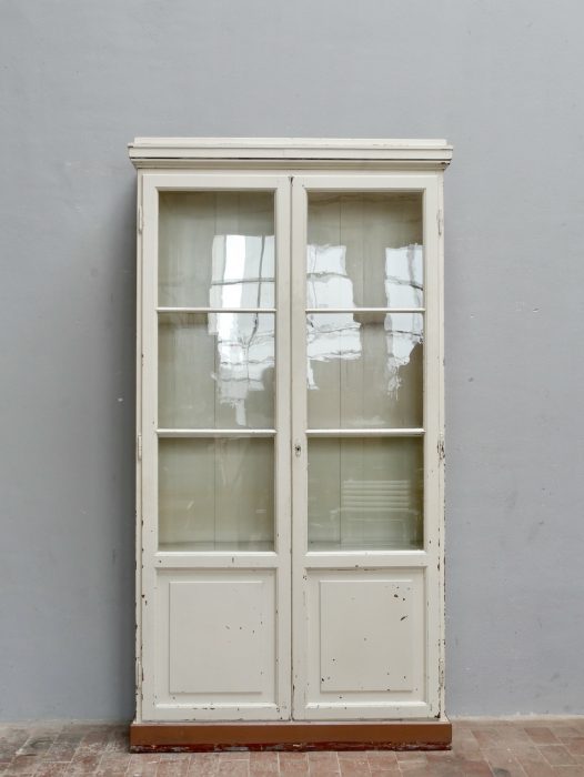 Frontalansicht des geschlossenen Lehrmittelschranks mit zwei großen verglasten Türen, originalem mundgeblasenem Glas und klassischer Bibliotheksgestaltung aus der Zeit um 1910.