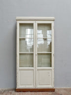 Frontalansicht des geschlossenen Lehrmittelschranks mit zwei großen verglasten Türen, originalem mundgeblasenem Glas und klassischer Bibliotheksgestaltung aus der Zeit um 1910.