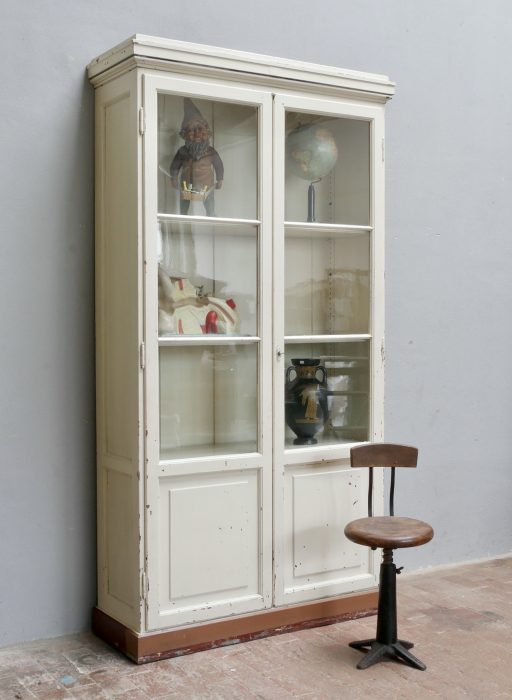 XXL Lehrmittelschrank / Bibliotheksschrank um 1910 aus der Humboldt-Universität Berlin. Die Hauptansicht zeigt den hohen zweitürigen Bücherschrank mit originalem mundgeblasenem Glas, schöner erhaltungswürdiger Farbpatina, aufwendig profilierter Kranzleiste und klassischer Bibliotheksausführung.