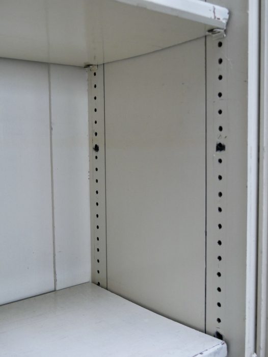 Detailaufnahme des Innenraums mit den massiven originalen Einlegeböden und den seitlichen Lochleisten zur flexiblen Höhenverstellung der Fachböden.
