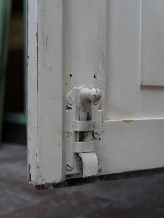 Detailaufnahme eines innenliegenden Originalscharniers. Die Scharniere ermöglichen ein Öffnen der Türen bis nahezu 180 Grad und gehören zur originalen Konstruktion des Schranks.