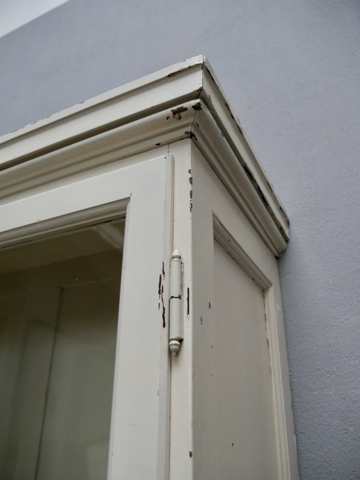 Detailaufnahme der oberen Schrankecke mit profilierter Kranzleiste und sauber ausgearbeiteten Übergängen zwischen Seitenwand und Gesims.