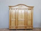 Frontalansicht des restaurierten Jugendstil-Kleiderschranks mit geschweifter Kranzleiste, drei Türen, geschnitzten Türfüllungen und drei Schubladen im Sockelbereich.