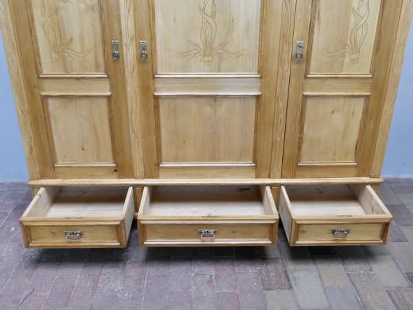 Geöffnete Sockelschubladen des restaurierten Jugendstil-Kleiderschranks. Die drei großzügigen Schubladen bieten zusätzlichen Stauraum und zeigen die hochwertige Verarbeitung.