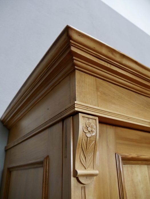 Detailaufnahme der seitlichen Kranzleiste mit geschnitztem Jugendstil-Ornament und profilierter Rahmenkonstruktion. Die feinen Holzarbeiten verdeutlichen die hochwertige handwerkliche Qualität.
